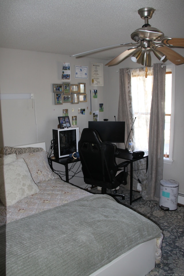 bedroom with ceiling fan and a textured ceiling