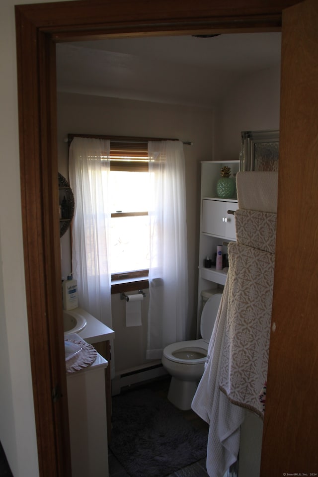 bathroom with vanity, toilet, and a baseboard heating unit