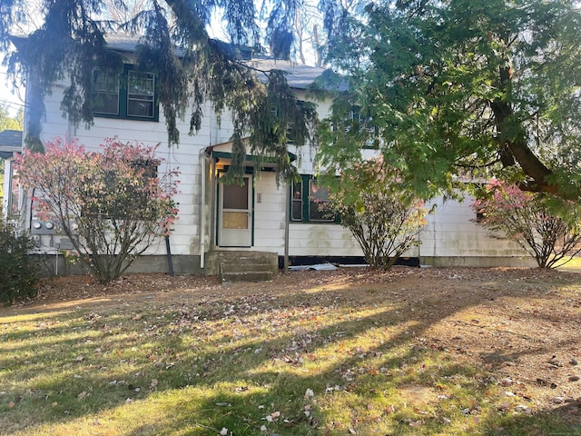 obstructed view of property with a front lawn