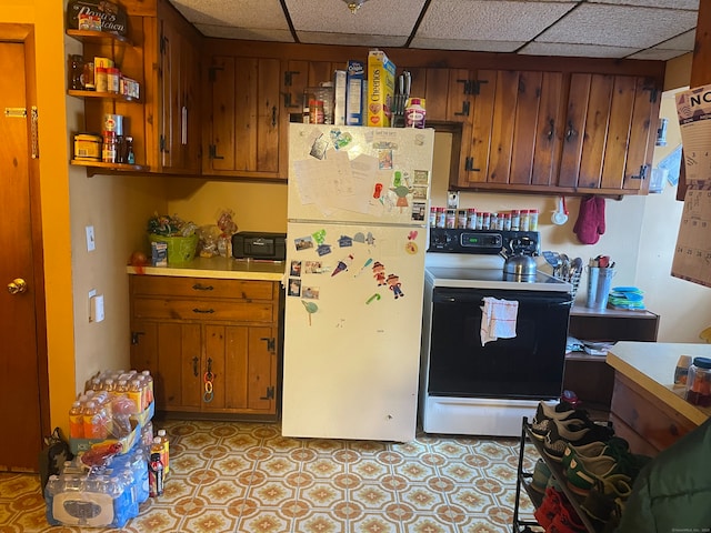 kitchen with white appliances and a paneled ceiling