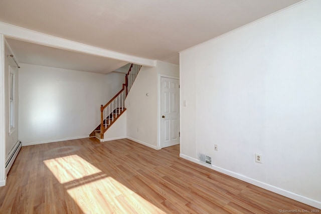 spare room with light wood-type flooring and baseboard heating