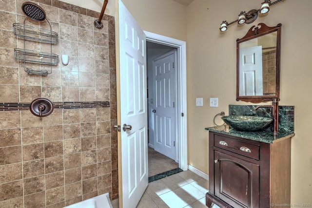 bathroom with vanity, tiled shower, and tile patterned floors