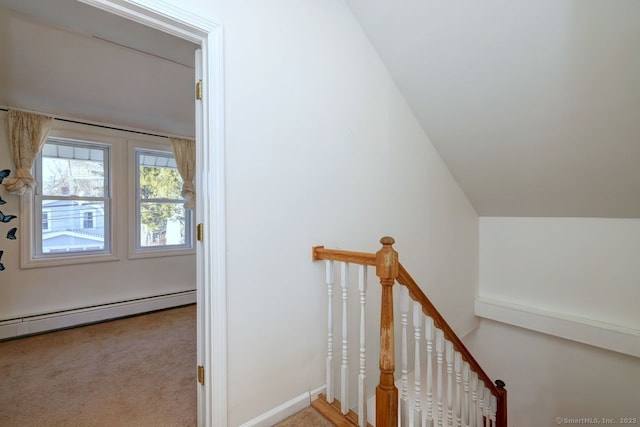 stairs with lofted ceiling, a baseboard heating unit, and carpet floors