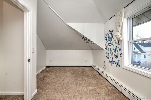 additional living space featuring light carpet, a baseboard heating unit, and vaulted ceiling