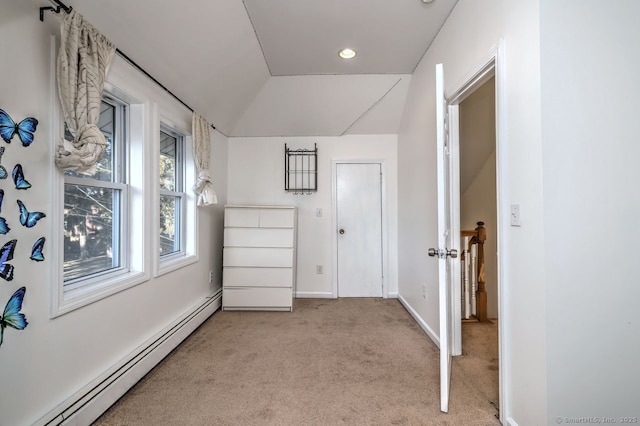 interior space with light carpet, a baseboard radiator, and vaulted ceiling