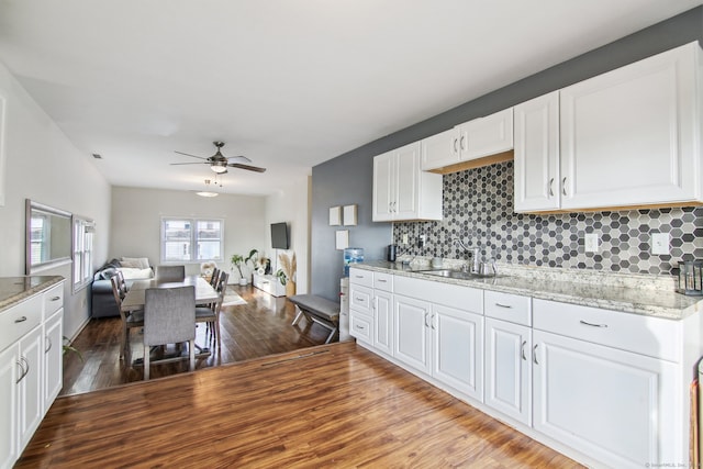 kitchen featuring backsplash, sink, ceiling fan, light hardwood / wood-style floors, and white cabinetry