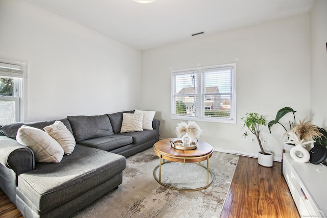 living room featuring dark hardwood / wood-style flooring and a healthy amount of sunlight