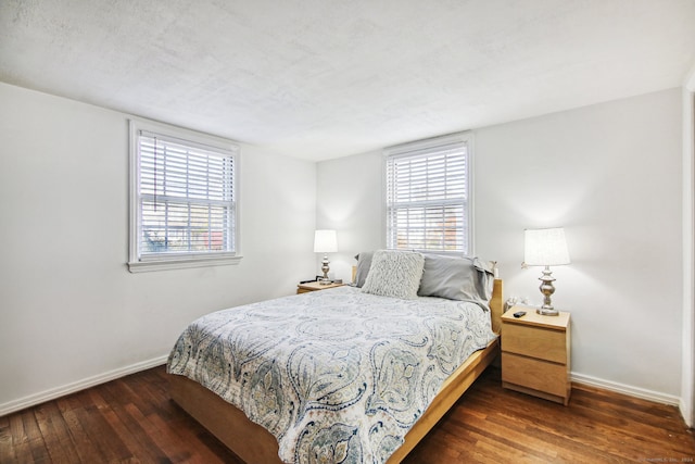 bedroom with a textured ceiling and dark wood-type flooring