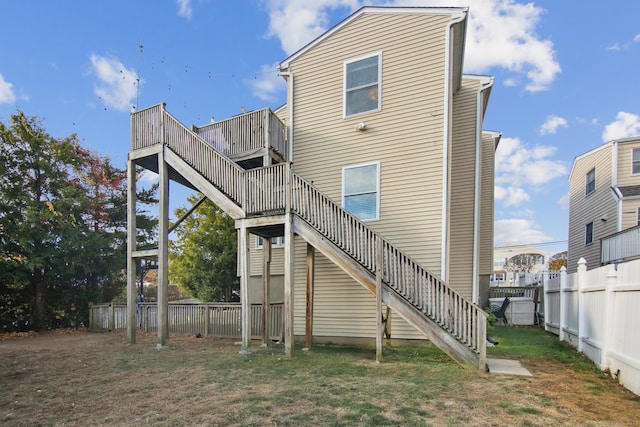 back of property featuring a deck and a yard