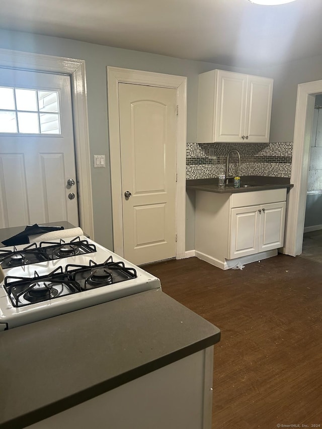 kitchen featuring tasteful backsplash, dark hardwood / wood-style flooring, white cabinets, and sink