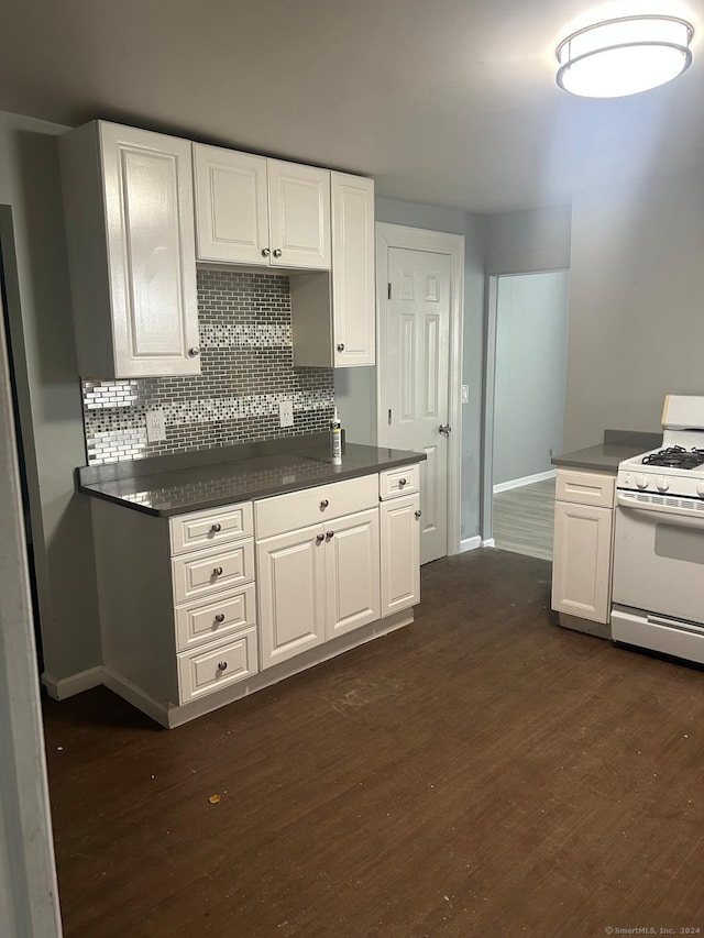 kitchen with white gas range, white cabinets, and dark hardwood / wood-style floors