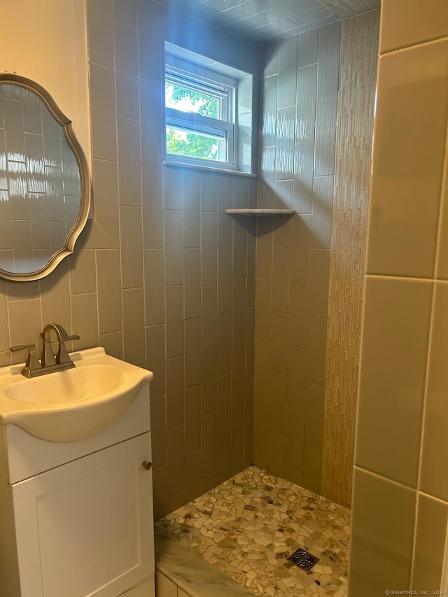 bathroom featuring tiled shower and vanity