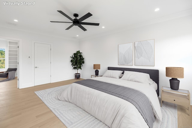 bedroom featuring ceiling fan, light hardwood / wood-style flooring, and ornamental molding