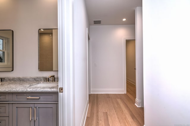 hall with light wood-type flooring and sink