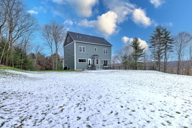 view of snow covered rear of property