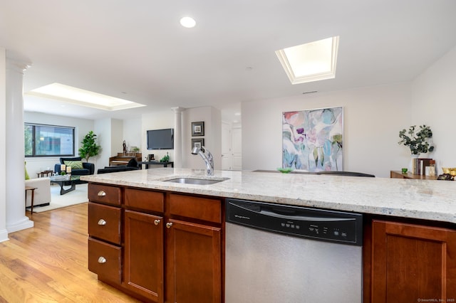 kitchen featuring sink, ornate columns, light wood-type flooring, stainless steel dishwasher, and light stone countertops