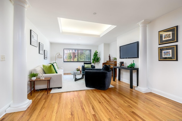 living room with decorative columns and light wood-type flooring