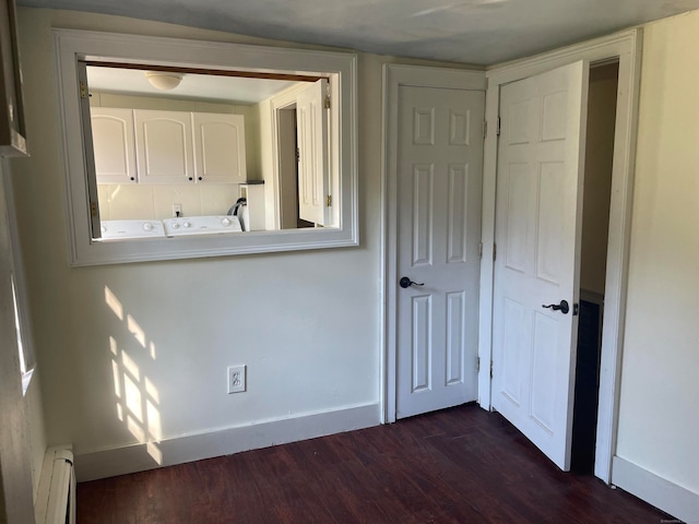 unfurnished bedroom with dark wood-type flooring and a baseboard heating unit