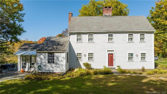 rear view of house featuring a yard