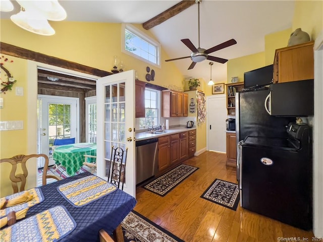 kitchen with plenty of natural light, beamed ceiling, stainless steel appliances, and light hardwood / wood-style flooring