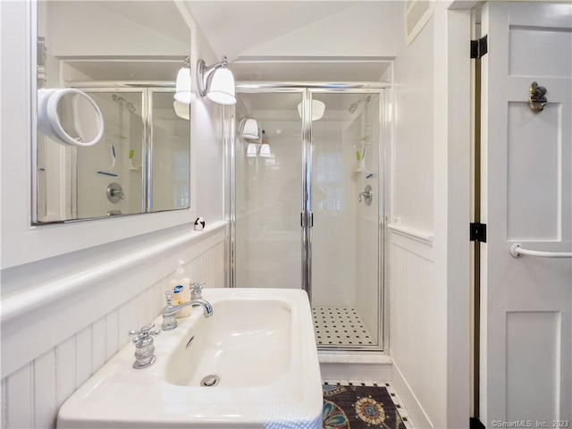 bathroom with lofted ceiling, tile patterned floors, a shower with shower door, and sink