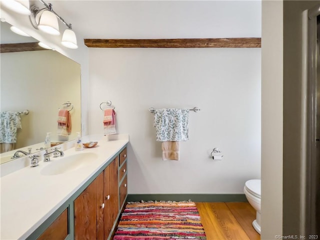 bathroom with vanity, hardwood / wood-style flooring, and toilet