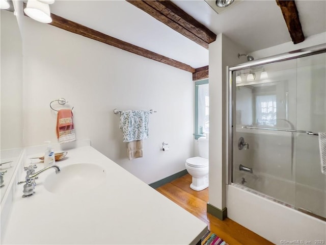 full bathroom featuring bath / shower combo with glass door, sink, hardwood / wood-style flooring, beamed ceiling, and toilet