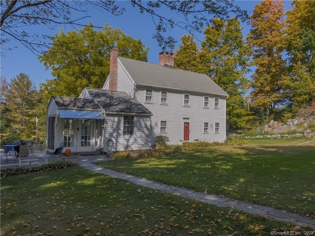 view of front of house featuring a front yard and french doors