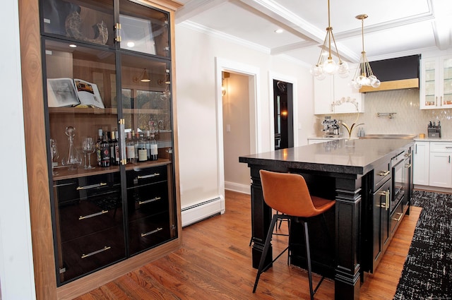 kitchen featuring white cabinetry, a center island, baseboard heating, a kitchen breakfast bar, and wood-type flooring