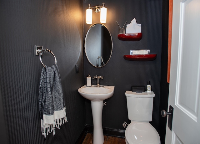 bathroom featuring wood-type flooring, toilet, and sink