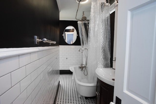 bathroom with ornamental molding, vanity, tile walls, tile patterned flooring, and a tub