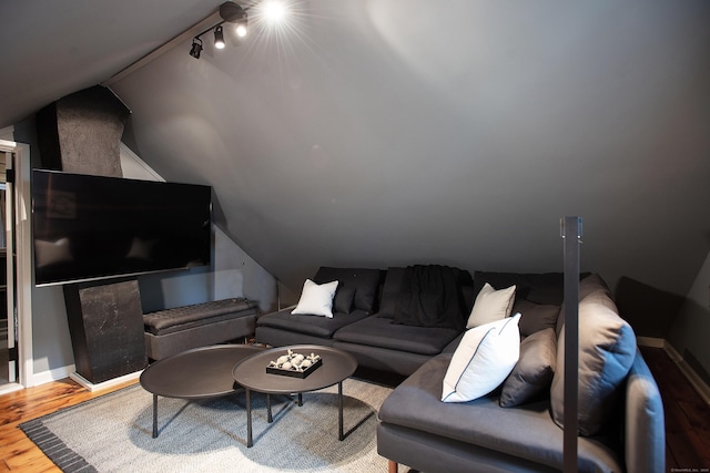 living room featuring wood-type flooring, rail lighting, and vaulted ceiling