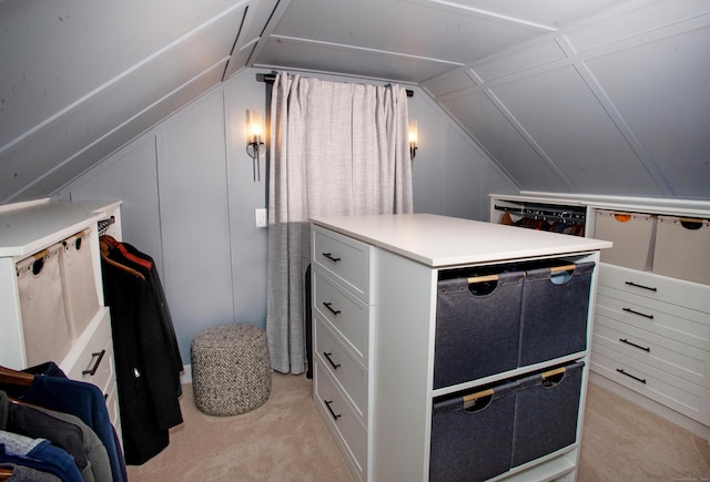 walk in closet with light carpet and vaulted ceiling