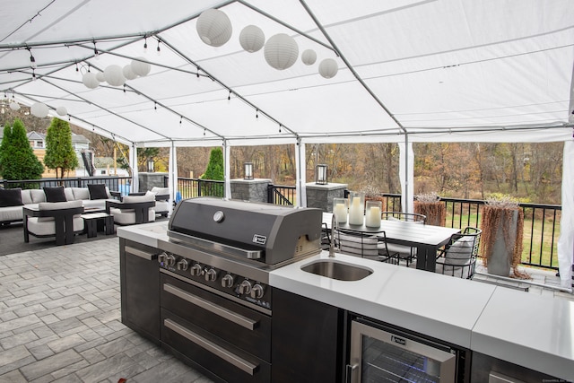 view of patio / terrace with an outdoor kitchen, an outdoor hangout area, sink, and beverage cooler