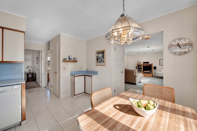 dining space with light tile patterned floors, track lighting, and a notable chandelier