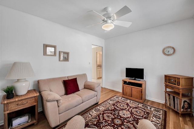 living area featuring light wood-style flooring and ceiling fan