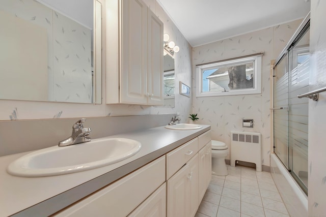 full bath featuring radiator heating unit, a sink, shower / bath combination with glass door, and wallpapered walls