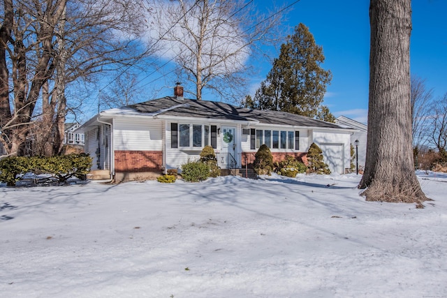 single story home featuring brick siding, a chimney, and an attached garage