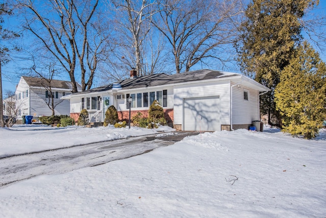 ranch-style house with a chimney and an attached garage