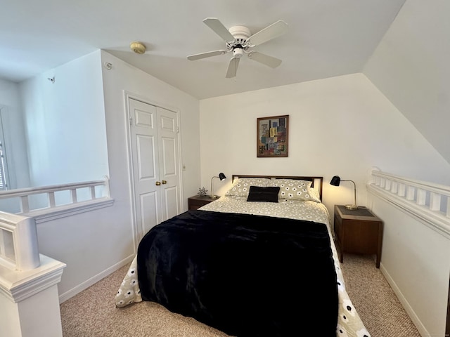 carpeted bedroom with ceiling fan, lofted ceiling, and a closet