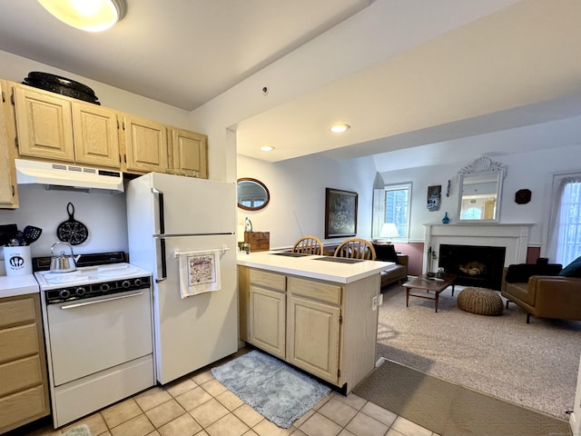 kitchen featuring a fireplace, light brown cabinets, and white appliances