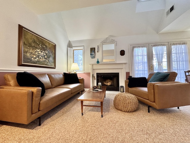 carpeted living room featuring lofted ceiling and a tiled fireplace