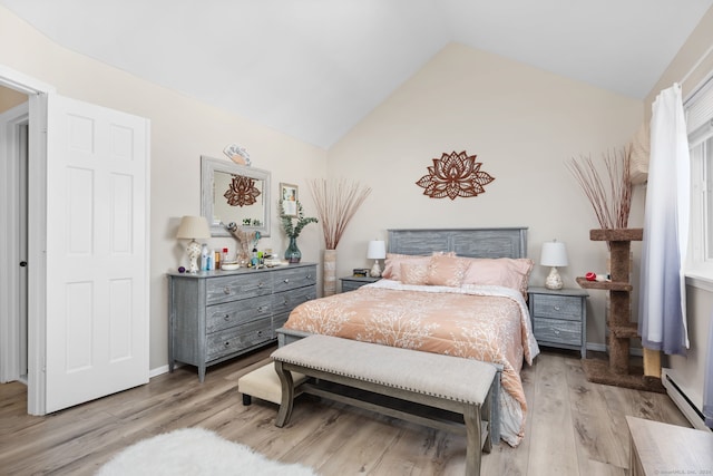 bedroom with light hardwood / wood-style flooring, a baseboard radiator, and vaulted ceiling