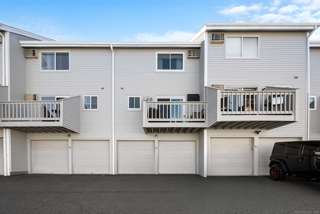 rear view of property with a balcony and a garage