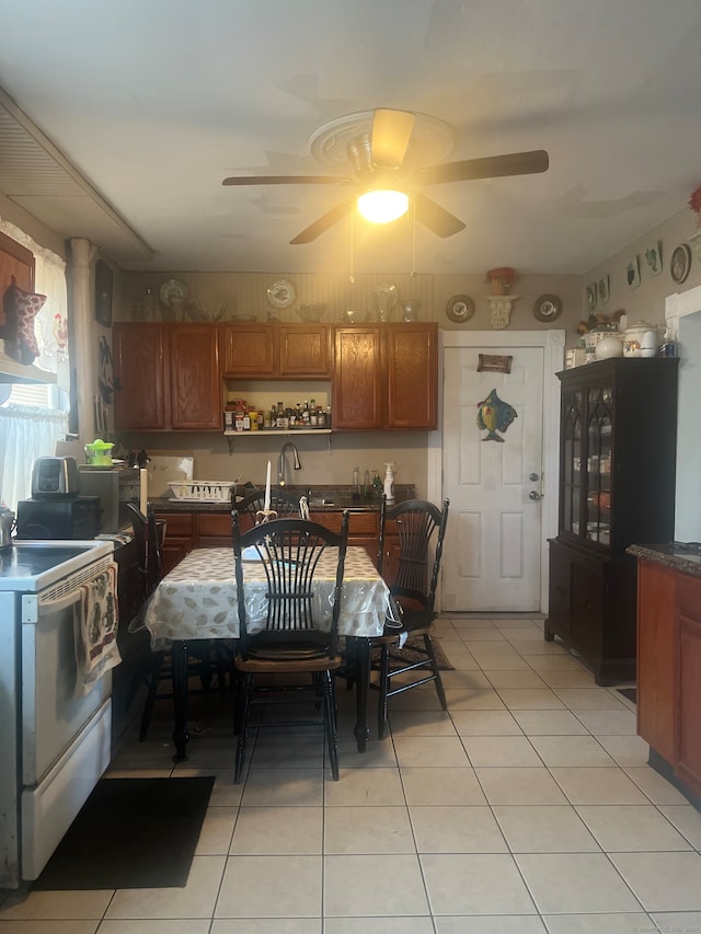 kitchen with ceiling fan, light tile patterned flooring, sink, and white stove