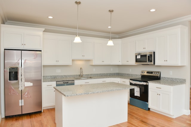 kitchen featuring stainless steel appliances, a kitchen island, white cabinetry, and sink