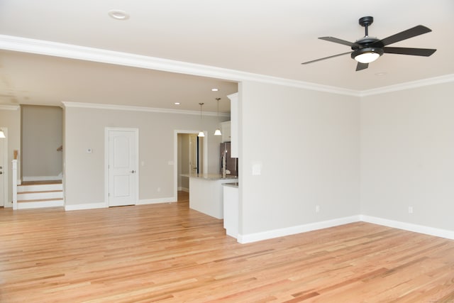 unfurnished living room with light hardwood / wood-style floors, ceiling fan, and ornamental molding