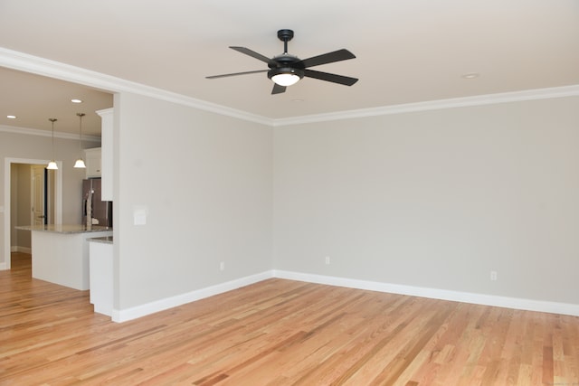 empty room featuring light hardwood / wood-style flooring, ceiling fan, and crown molding