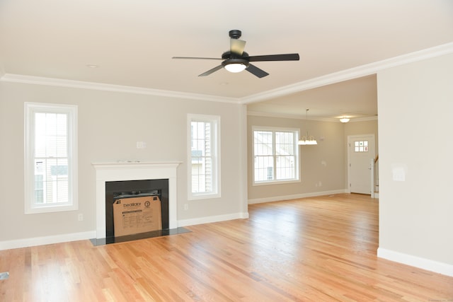 unfurnished living room featuring ceiling fan with notable chandelier, light hardwood / wood-style flooring, and crown molding