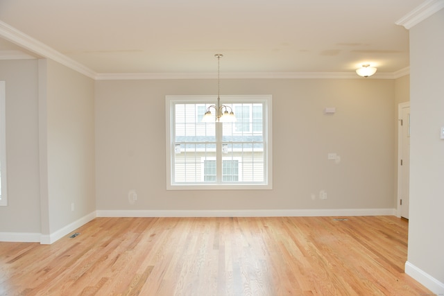 empty room featuring a notable chandelier, light hardwood / wood-style floors, and crown molding